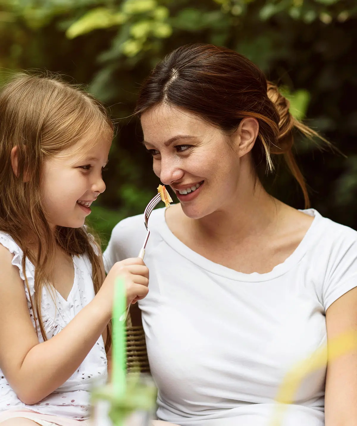 A parent and child enjoying a moment while having a picnic