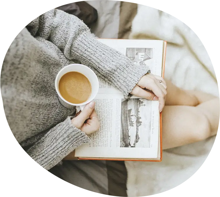 A person relaxing with a hot drink and a book