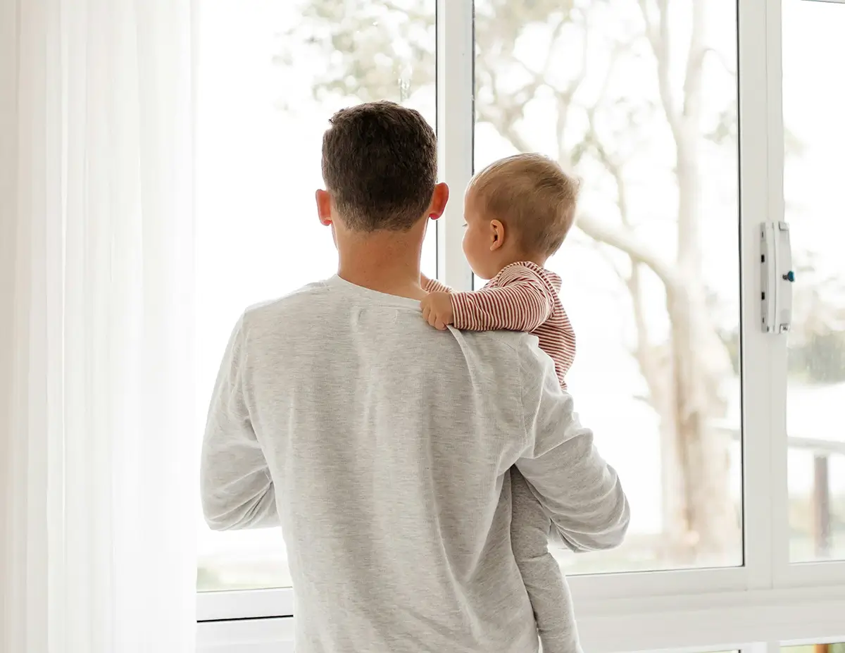 A father and child looking out clean windows